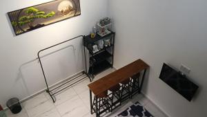 a room with a wooden bench and a shelf at Rembulan Guesthouse in Mersing