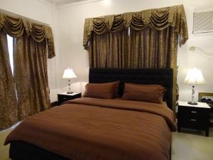 una camera con un grande letto con due lampade di The Executive Villa Inn & Suites a Davao Altre 32 foto