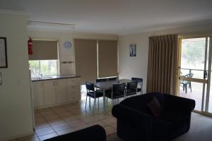 a living room with a kitchen and a table and chairs at Tooleybuc River Retreat Villas in Tooleybuc