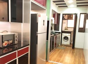 una cucina con frigorifero, lavatrice e asciugatrice di Putra Villa Short Stay Apartment KL a Kuala Lumpur