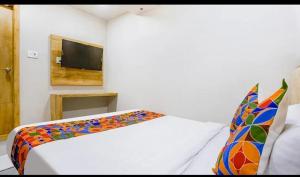 a bedroom with a bed and a tv on the wall at Hotel Baghdad Palace in Mumbai +4 photos