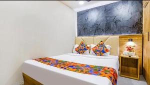 a bedroom with two beds and a painting on the wall at Hotel Baghdad Palace in Mumbai