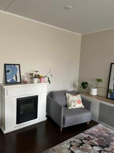 a living room with a chair and a fireplace at Saunallinen kolmio kahdella autopaikalla in Jyväskylä