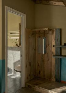 a bathroom with a wooden wall with a mirror at TONG Boutique Hotel in Phan Thiet +55 photos