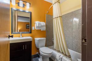 a bathroom with a toilet and a sink and a mirror at Quality Inn Grand Rapids Near Downtown in Grand Rapids +79 photos