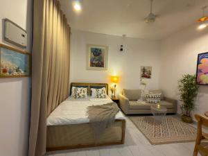a bedroom with a bed and a couch at Kai Apartments Near Airport Zanzibar in Zanzibar City