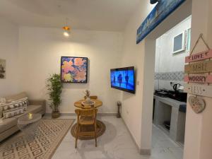 a living room with a table and a tv on a wall at Kai Apartments Near Airport Zanzibar in Zanzibar City
