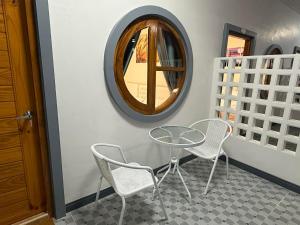 a table and chairs in a room with a mirror at Kasalong stay in Ban Nong Chaeng