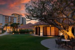 a house with a lawn and a table and chairs at PGM Hotel Resort Okinawa in Onna