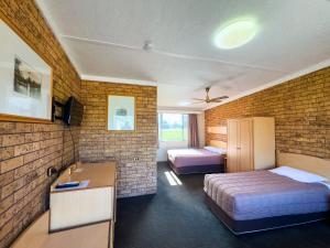 a hotel room with two beds and a desk at Nandewar Motor Inn in Narrabri +115 photos