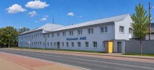 a large white building on the side of a street at Ubytování AMZ in Vrábí