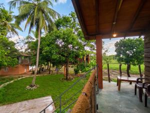 a porch of a house with a bench and trees at Vercour Tree House Cabana Sigiriya in Sigiriya