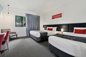 a hotel room with two beds and a table at Quality Resort Parkhurst in Rockhampton +91 photos
