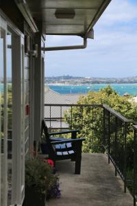 um alpendre com um banco ao lado de uma casa em Abaco on Jervois em Auckland