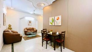 a living room with a table and leather chairs at Olive Serviced Apartments - Central Delhi in New Delhi