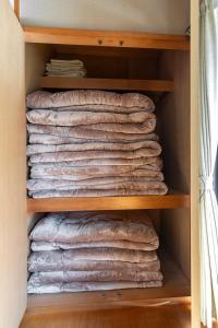 a pile of towels in a closet at Guest House Masaru ゲストハウス勝 in Nagano