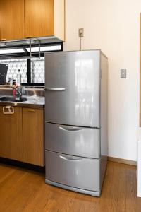 a large stainless steel refrigerator in a kitchen at Guest House Masaru ゲストハウス勝 in Nagano