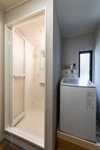 a small bathroom with a washer and dryer in a room at Guest House Masaru ゲストハウス勝 in Nagano