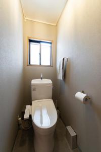 a bathroom with a toilet with a phone on the wall at Guest House Masaru ゲストハウス勝 in Nagano +70 photos
