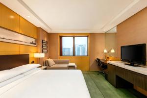 a hotel room with a bed and a flat screen tv at Shanghai Qilu Hotel in Shanghai +32 photos