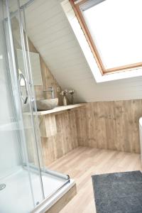 een badkamer op zolder met een douche en een wastafel bij Hof Ter Meulen in De Haan