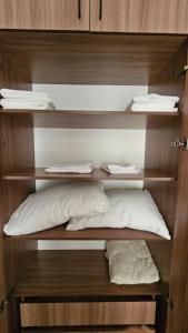 a room with wooden shelves with a pillow and towels at Sayram in Yunusobod
