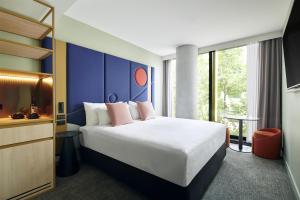 a hotel room with a bed and a large window at Quincy Hotel Melbourne in Melbourne