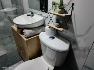 a bathroom with a white toilet and a sink at Room cerca al aeropuerto #3 in Bogotá +11 photos
