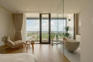 a bedroom with a tub and a view of the ocean at Elora House in Thôn Lại Thê