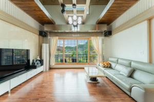 a living room with a couch and a television at U&I Pension in Yangyang