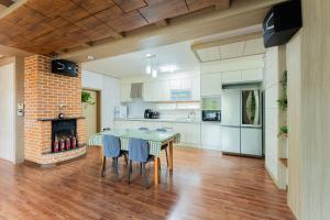 a kitchen and dining room with a table and a fireplace at U&I Pension in Yangyang