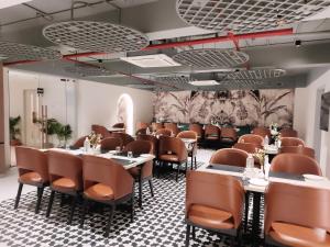 a restaurant with tables and chairs in a room at The Saffron Hotel in Bhubaneshwar