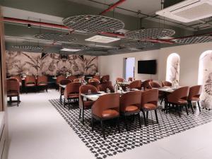 a conference room with tables and chairs and a screen at The Saffron Hotel in Bhubaneshwar