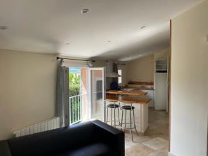a living room with a kitchen and a balcony at Hotel D'Albion in Sault-de-Vaucluse