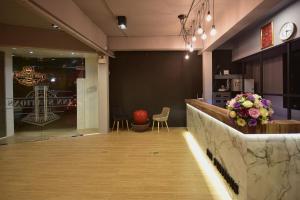 a lobby with a bar with flowers on the counter at Inn Stations Hostel in Bangkok