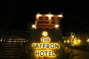 a sign in front of a hotel at night at The Saffron Hotel in Bhubaneshwar