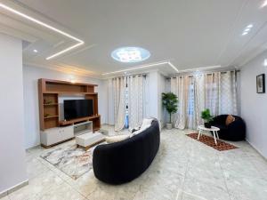 a living room with a couch and a tv at Egel appartement in Yaoundé