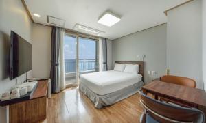 a hotel room with a bed and a desk and window at Mud Beach Hotel in Boryeong +31 photos