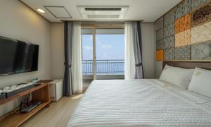 a bedroom with a large bed and a television at Mud Beach Hotel in Boryeong