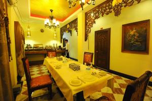 une salle à manger avec une table et des chaises ainsi qu'une cuisine dans l'établissement Union Square Hotel, à Yangon