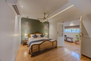 a bedroom with a king sized bed and a hallway at Goan Bliss Alaya Stays by ELIVAAS in Varca