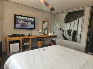 a bedroom with a bed and a tv on the wall at Ocean View Haute Hotel in Busan
