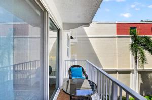 a balcony with a glass table and a chair at Moorings Pool Overview Resort in Lantana