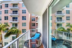 a balcony with a table and chairs and a building at Moorings Pool Overview Resort in Lantana