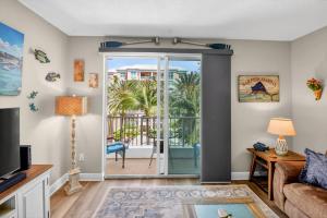 a living room with a door open to a patio at Moorings Pool Overview Resort in Lantana +19 photos