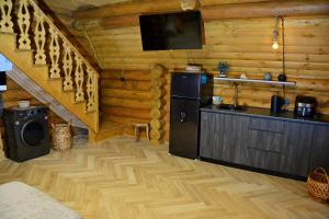 a kitchen with a refrigerator and a tv in a log cabin at Cottages Vakhrama in Abastumani
