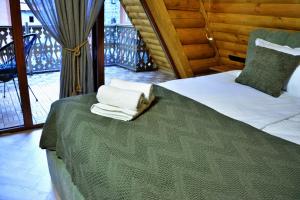 a bedroom with a bed with two towels on it at Cottages Vakhrama in Abastumani