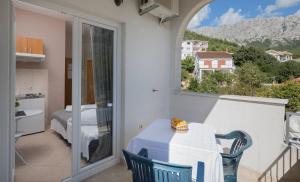 a balcony with a table and a view of a bedroom at Apartments Barbarić in Zaostrog