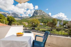 a table and chairs on a balcony with mountains at Apartments Barbarić in Zaostrog