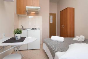 a small kitchen with a bed and a sink at Apartments Barbarić in Zaostrog